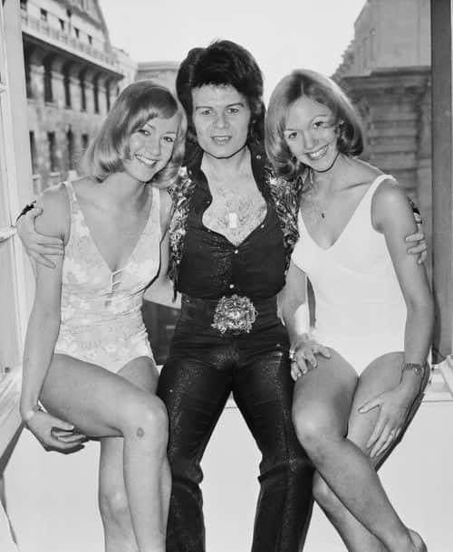 English pop singer Gary Glitter with Miss Great Britain, Gay Spink, right) and her sister Zoe at the Waldorf Hotel, London, 15th March 1973. (Photo by James Jackson/Hulton Archive/Getty Images)