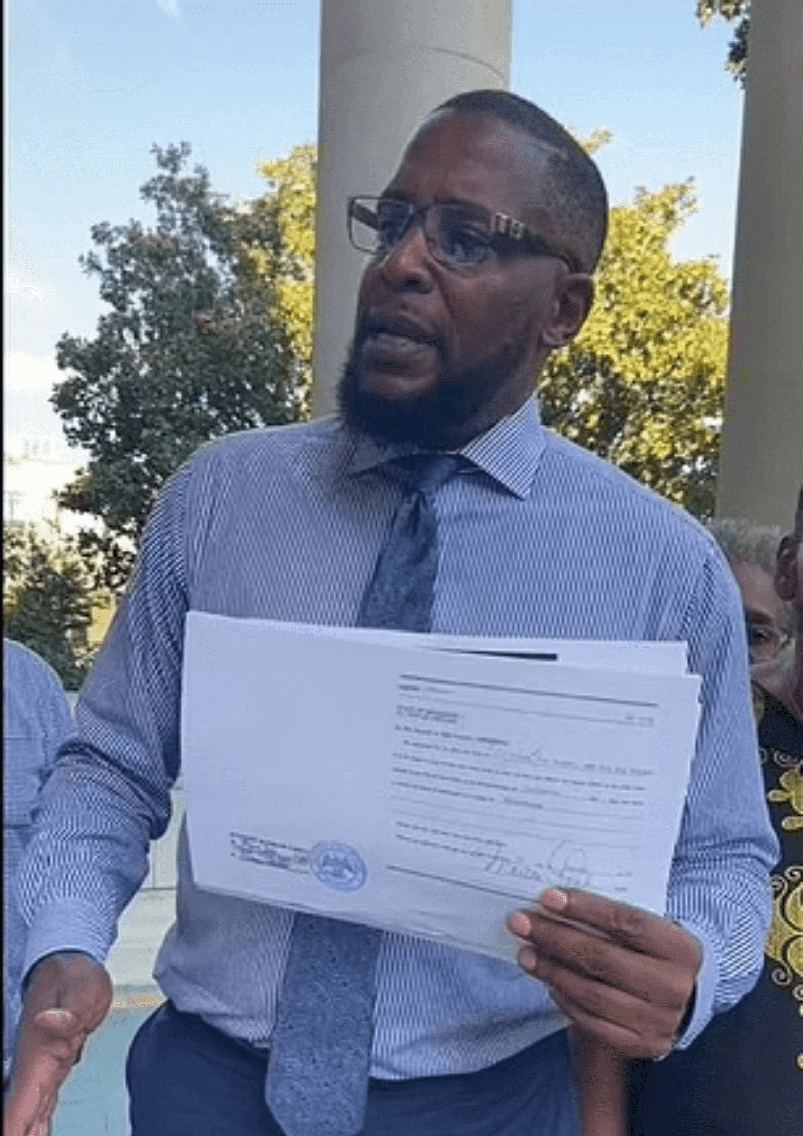 Malik Z Shabazz is pictured holding the warrant (Credits: Malik Z. Shabazz/Facebook)