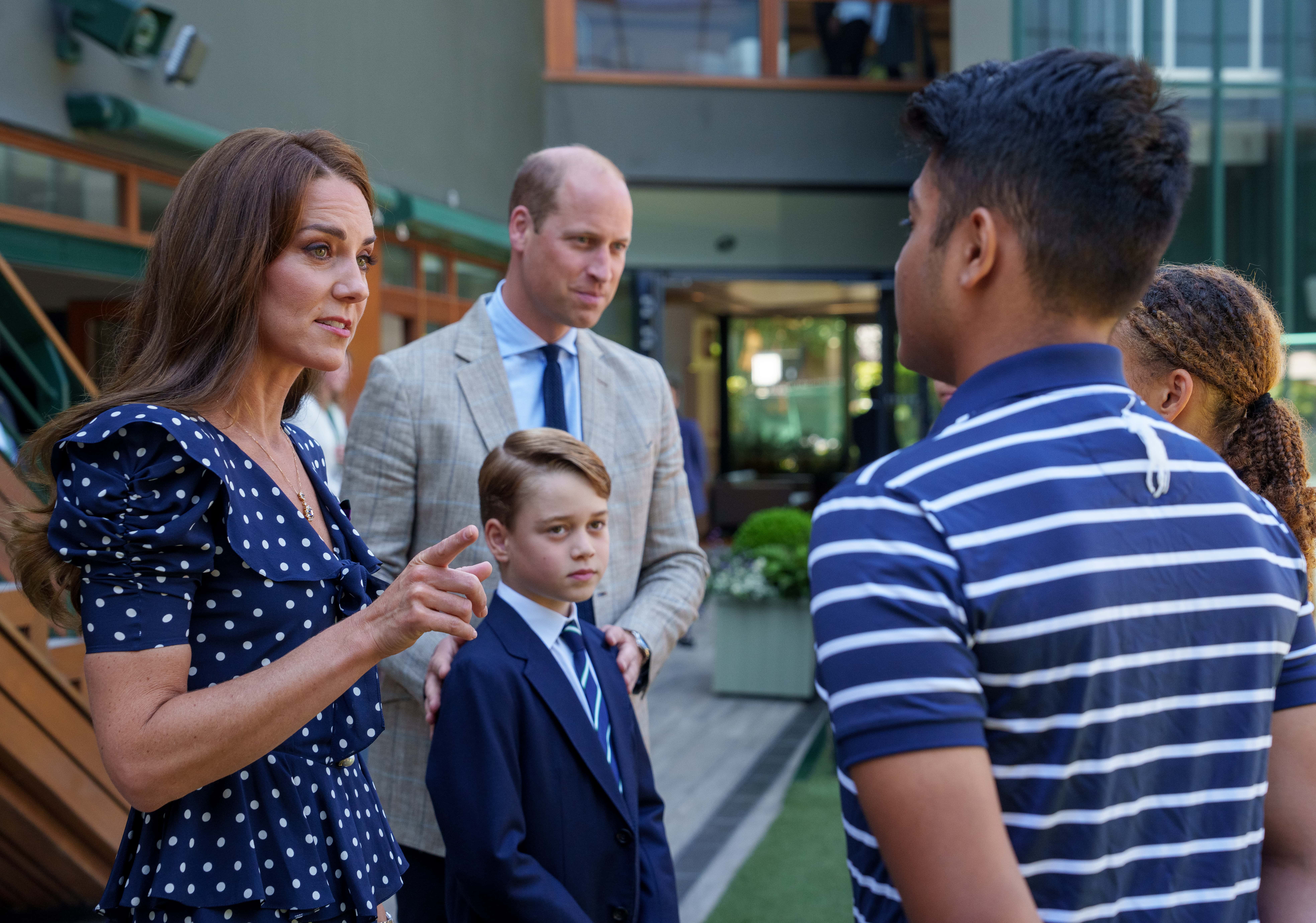 The Duke and Duchess of Cambridge with Prince George speak with Ball Boys & Ball Girls Syed Are, Dior Knorr and Amy Grange on their arrival on day fourteen of the 2022 Wimbledon Championships at the All England Lawn Tennis and Croquet Club, Wimbledon on July 10, 2022 in London, England. (Photo Thomas Lovelock/AELTC - Pool/Getty Images)