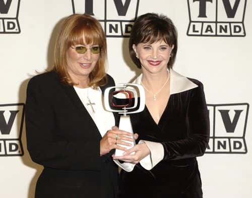 Actresses Penny Marshall and Cindy Williams pose backstage with their Working Stiff of the Year award for 