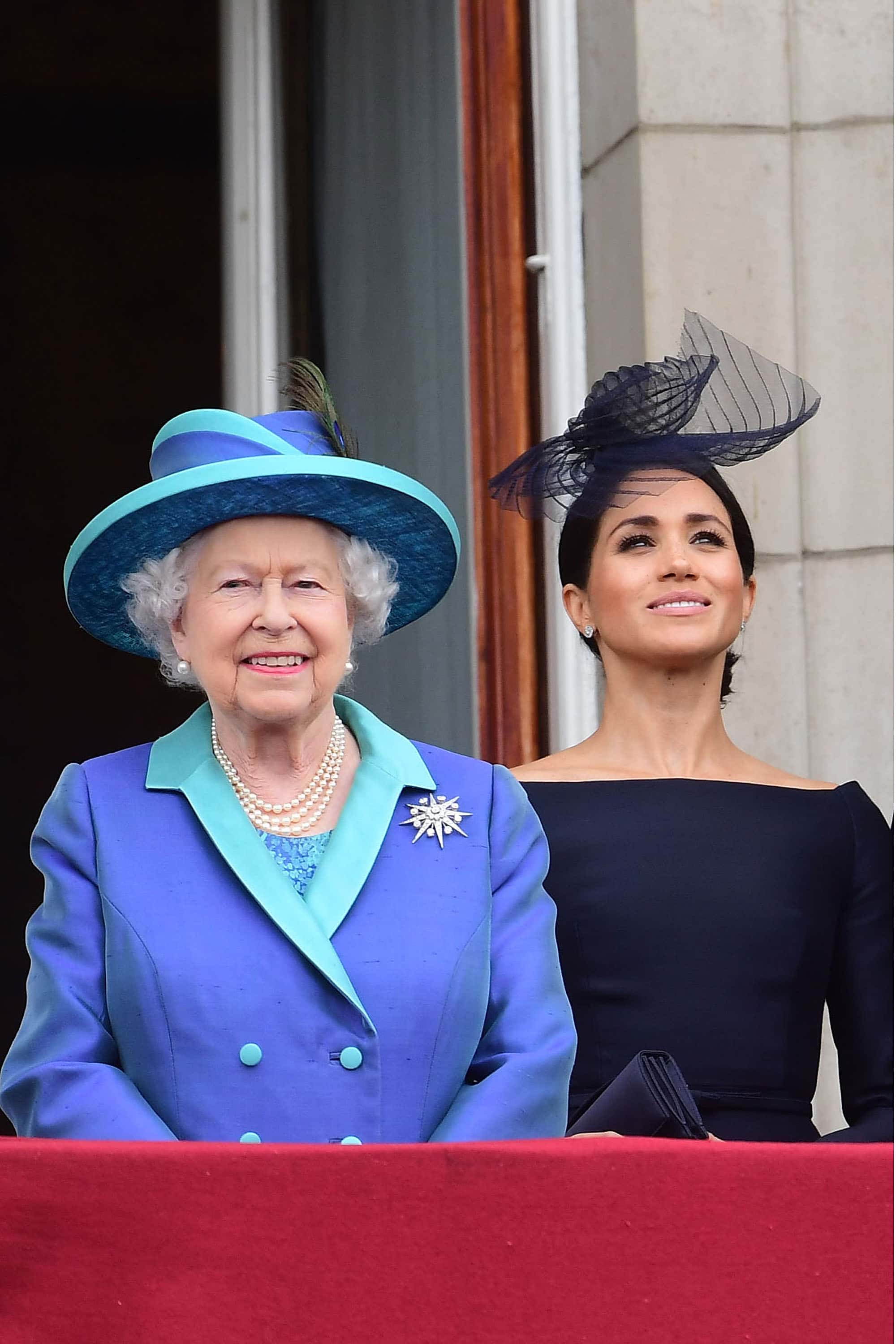 LONDON, ENGLAND - JULY 10:  Queen Elizabeth II and Meghan, Duchess of Sussex watch the RAF 100th anniversary flypast from the balcony of Buckingham Palace on July 10, 2018 in London, England.