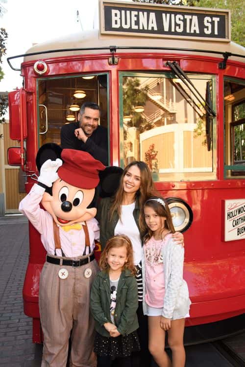 In this handout photo provided by Disney Parks, Actress Jessica Alba, husband Cash Warren and daughters Honor and Haven take a ride with Mickey Mouse on the Red Car Trolley at Disney California Adventure Park on March 31, 2017 in Anaheim, California.