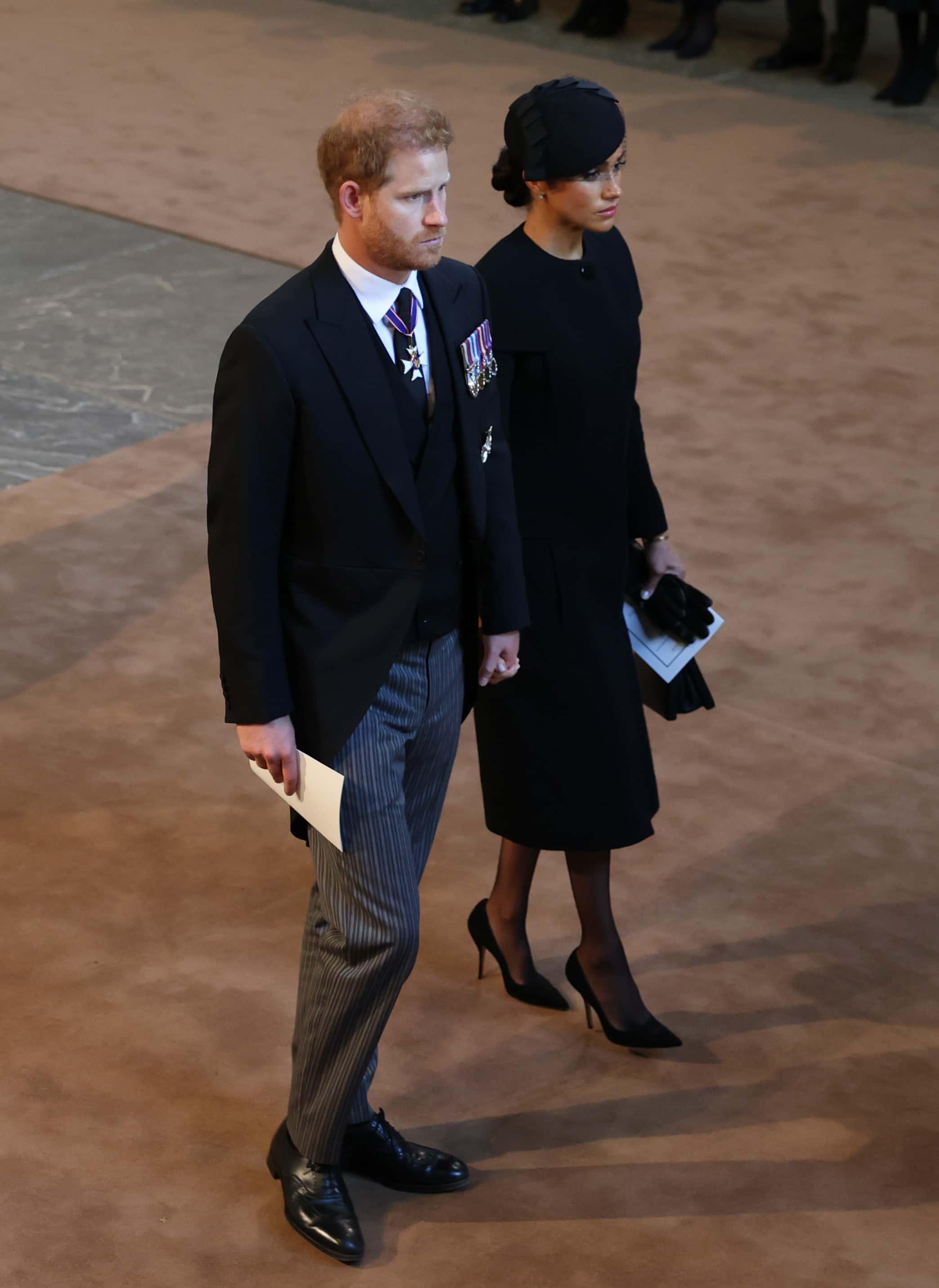 Prince Harry, Duke of Sussex and Meghan, Duchess of Sussex attend as the coffin of Queen Elizabeth II is escorted into Westminster Hall  for the Lying-in State on September 14, 2022 in London, England. Queen Elizabeth II's coffin is taken in procession on a Gun Carriage of The King's Troop Royal Horse Artillery from Buckingham Palace to Westminster Hall where she will lay in state until the early morning of her funeral. Queen Elizabeth II died at Balmoral Castle in Scotland on September 8, 2022, and is succeeded by her eldest son, King Charles III.