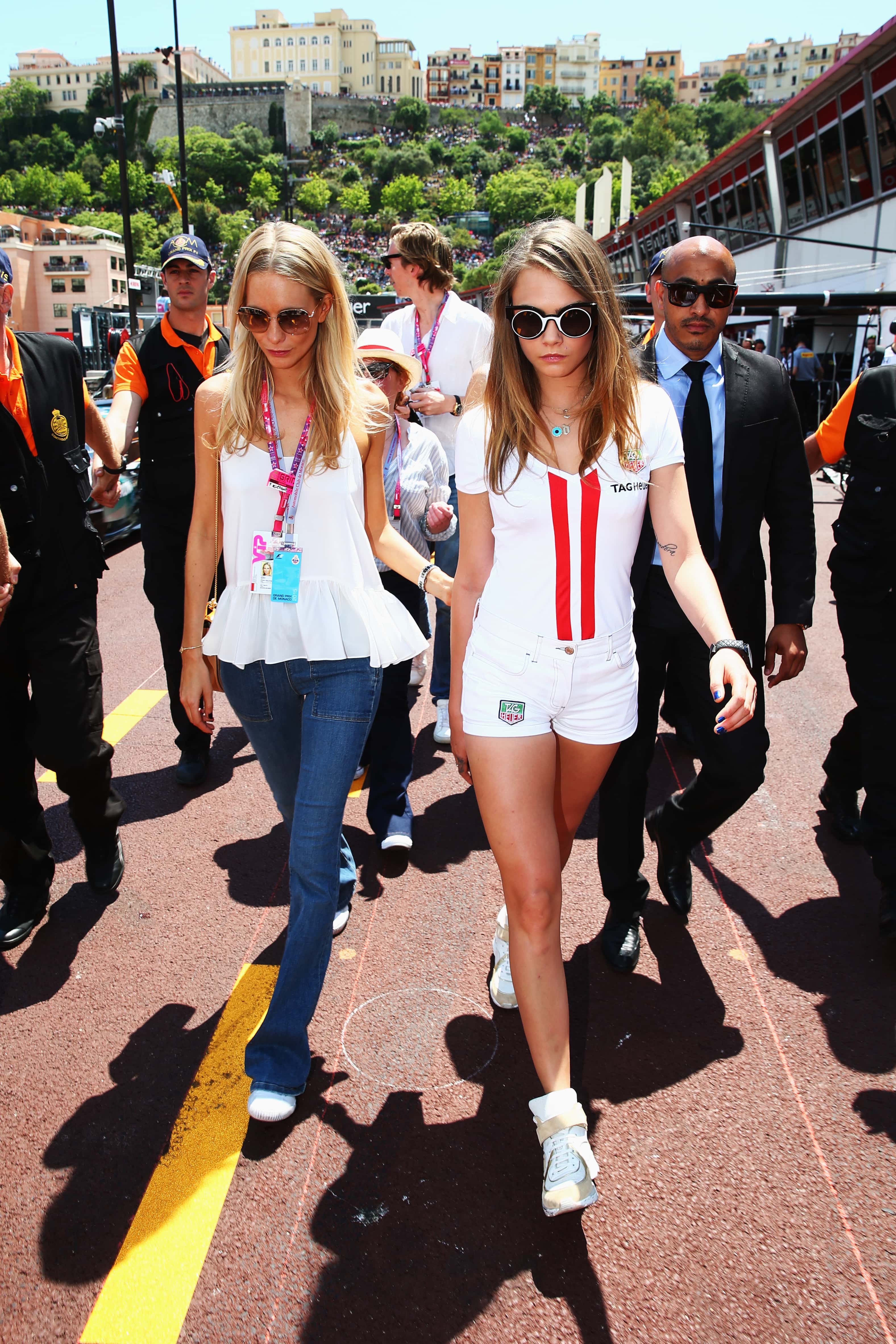 (L-R) Poppy Delevingne and Cara Delevingne walk down the pitlane before the start of the Monaco Formula One Grand Prix at Circuit de Monaco on May 24, 2015 in Monte-Carlo, Monaco.