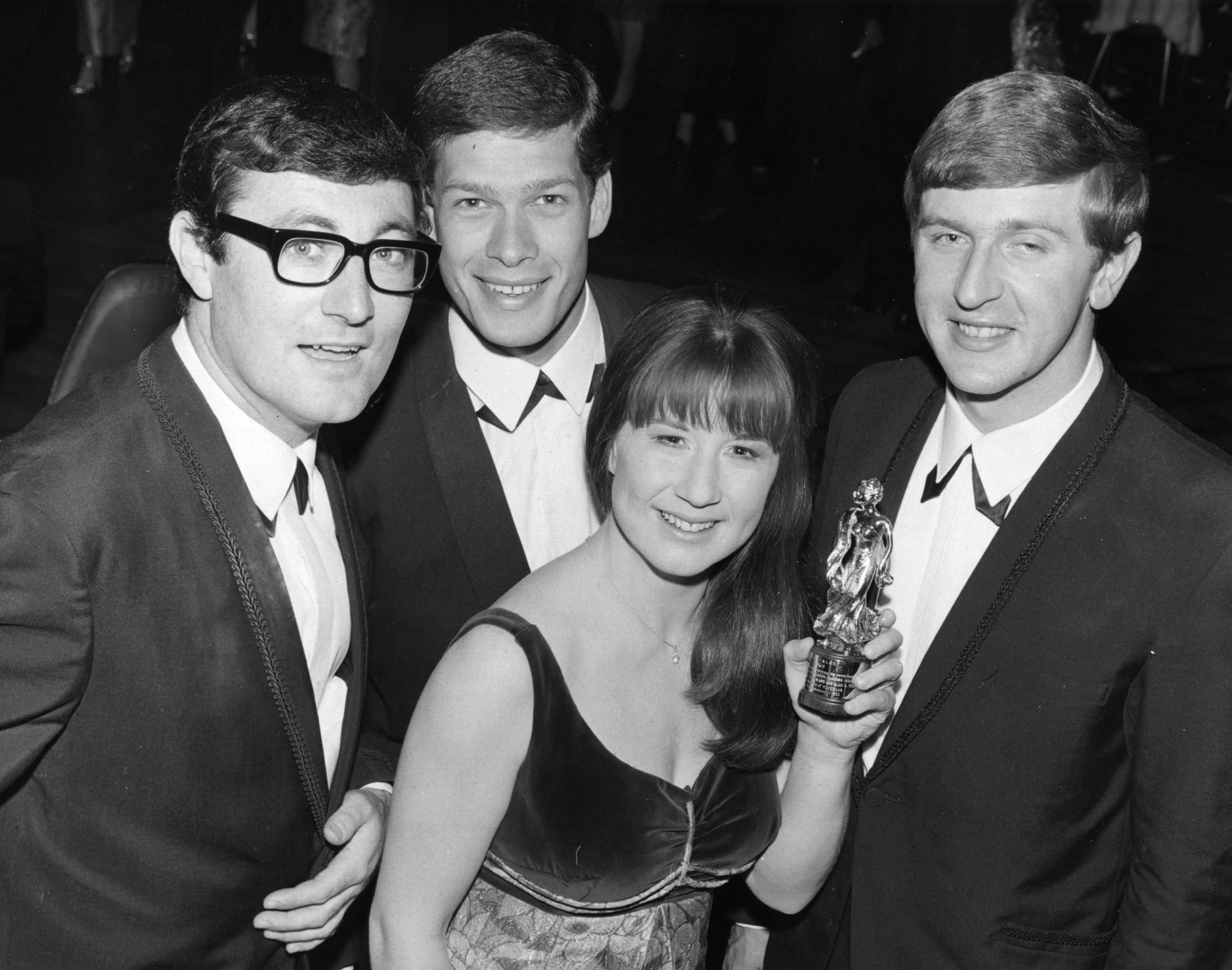 Australian pop group The Seekers brandishing their Carl Alan Award for Best New Group Of 1965, at the Empire Ballroom, Leicester Square, London. The award was presented to the group by Dame Margot Fonteyn. From left to right, Athol Guy, Keith Potger, Judith Durham and Bruce Woodley.