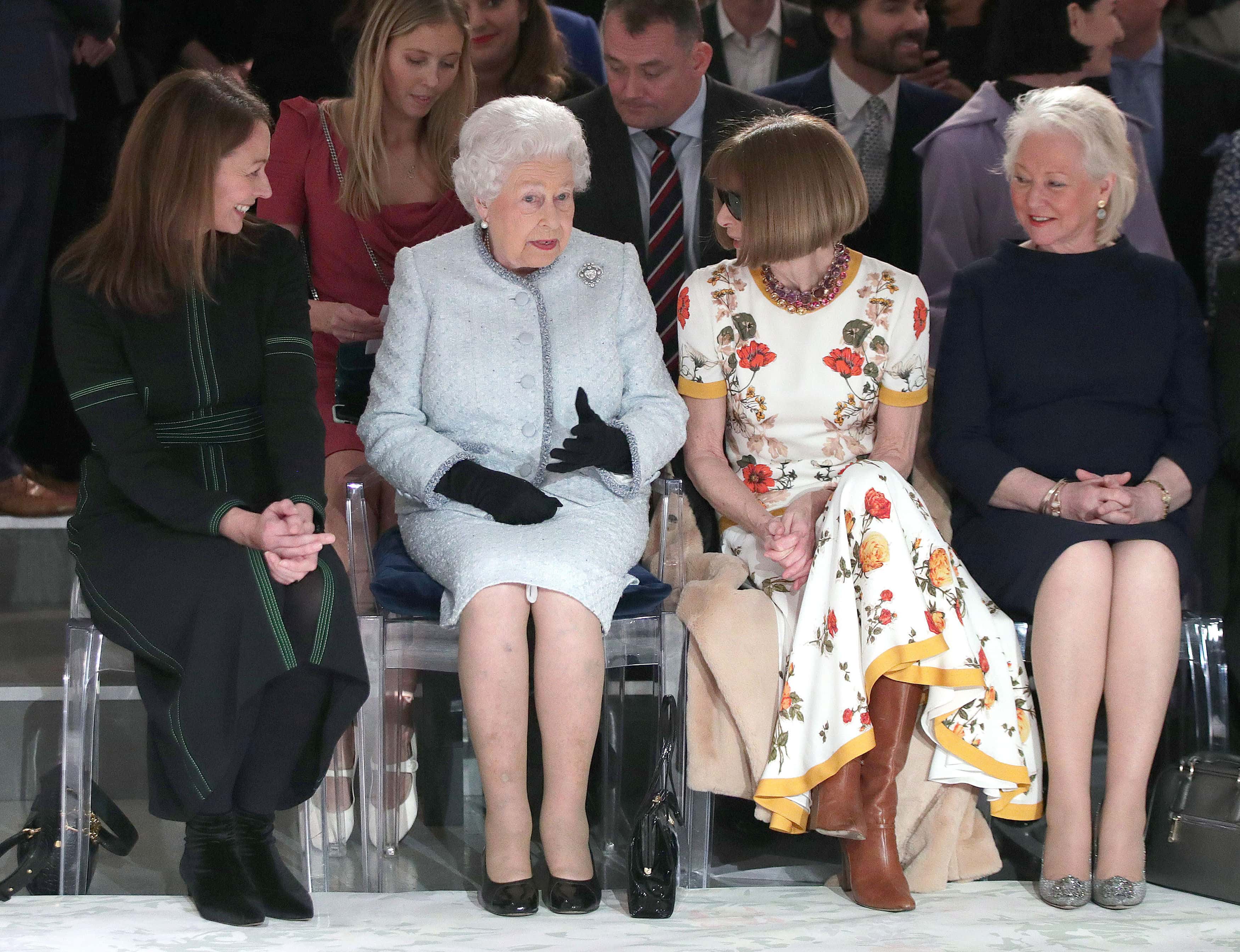 Queen Elizabeth II sits with Anna Wintour, Caroline Rush (L), chief executive of the British Fashion Council (BFC) and royal dressmaker Angela Kelly (R) as they view Richard Quinn's runway show before presenting him with the inaugural Queen Elizabeth II Award for British Design as she visits London Fashion Week's BFC Show Space on February 20, 2018 in London, United Kingdom.