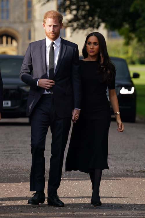 Prince Harry, Duke of Sussex, and Meghan, Duchess of Sussex walk together to meet members of the public on the long Walk at Windsor Castle on September 10, 2022 in Windsor, England. Crowds have gathered and tributes left at the gates of Windsor Castle to Queen Elizabeth II, who died at Balmoral Castle on 8 September, 2022.