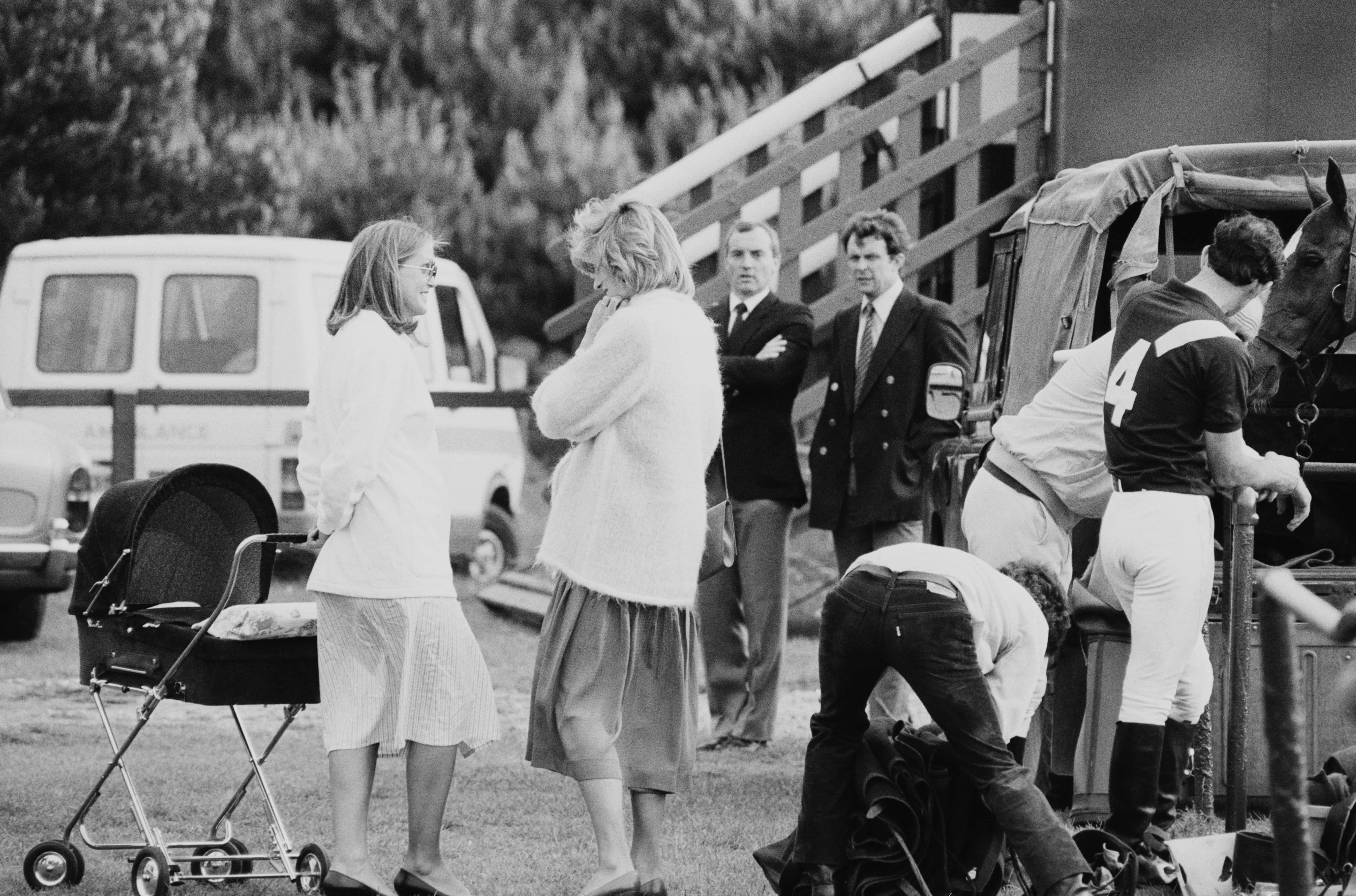 Diana, the Princess of Wales (1961 - 1997), pregnant with Prince Harry, chats while at a polo event with Prince Charles (wearing polo jersey #4), as bodyguard Barry Mannakee (third from left) looks on, Windsor, UK, 8th June 1984. (Photo by Steve Wood/Daily Express/Hulton Archive/Getty Images)