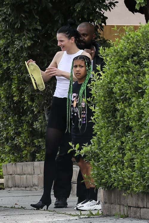 North seemingly twinned with her father in an all-black outfit that she styled with a pair of Yeezy white sneakers. (Backgrid)