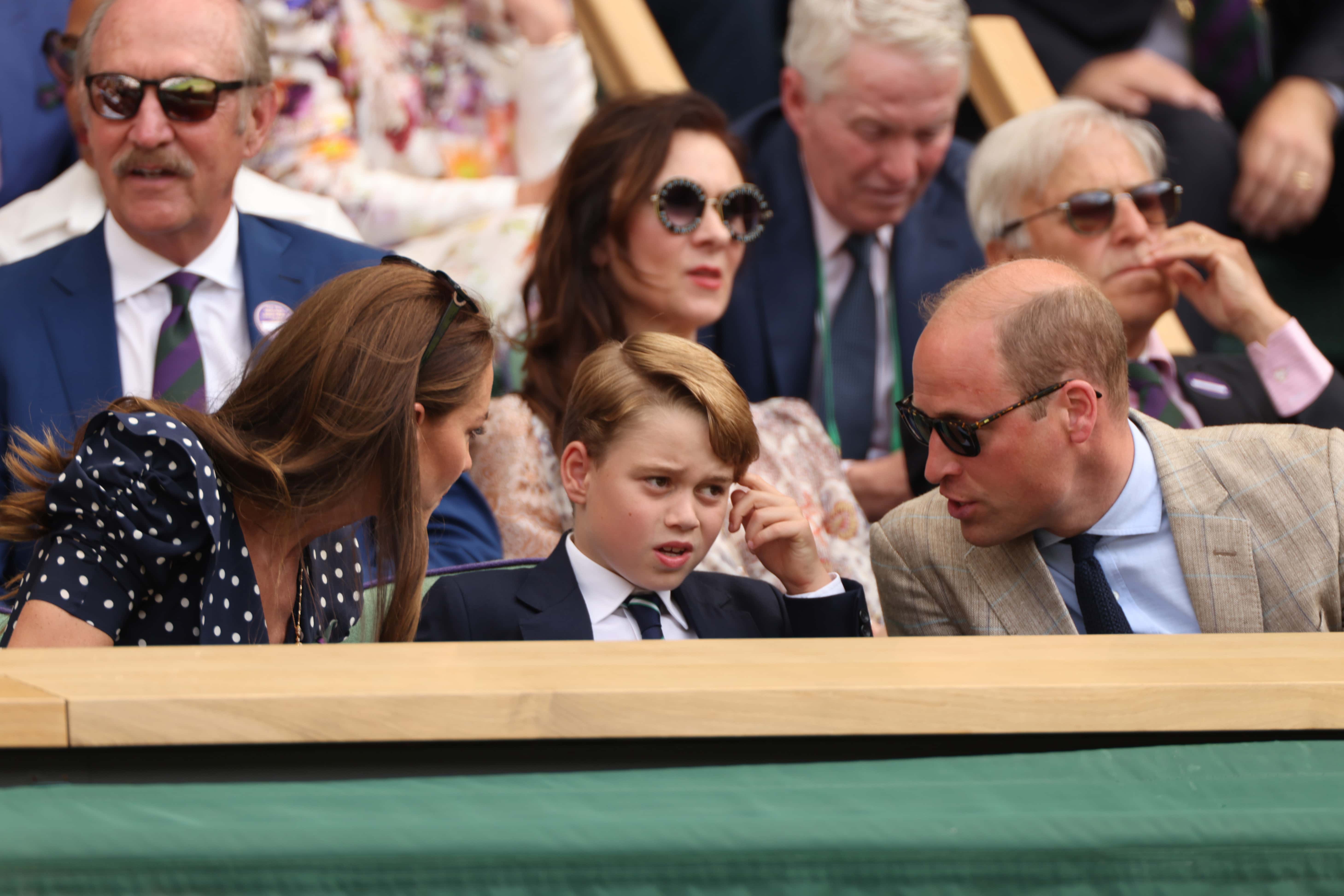 (L-R) Catherine, Duchess of Cambridge, Prince George of Cambridge and Prince William, Duke of Cambridge interact in the Royal Box watching Novak Djokovic of Serbia play Nick Kyrgios of Australia during their Men's Singles Final match on day fourteen of The Championships Wimbledon 2022 at All England Lawn Tennis and Croquet Club on July 10, 2022 in London, England. (Photo by Clive Brunskill/Getty Images)
