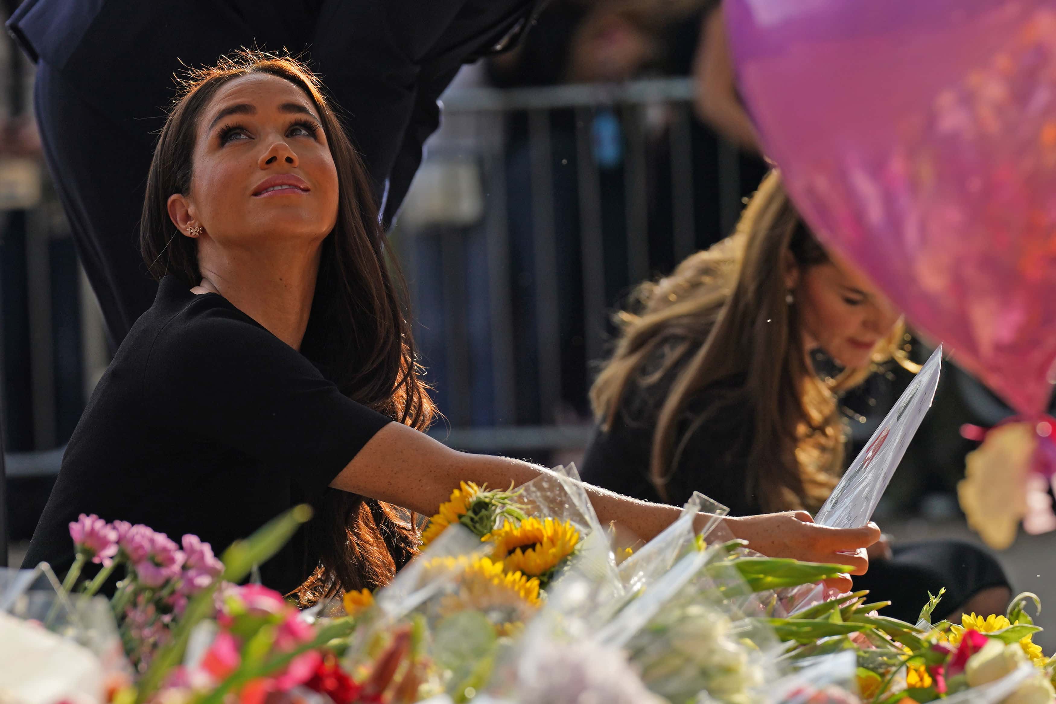 Meghan, Duchess of Sussex and Catherine, Princess of Wales view floral tributes left at Windsor Castle on September 10, 2022 in Windsor, England. Crowds have gathered and tributes left at the gates of Windsor Castle to Queen Elizabeth II, who died at Balmoral Castle on 8 September, 2022. (Photo by Kirsty O'Connor - WPA Pool/Getty Images)
