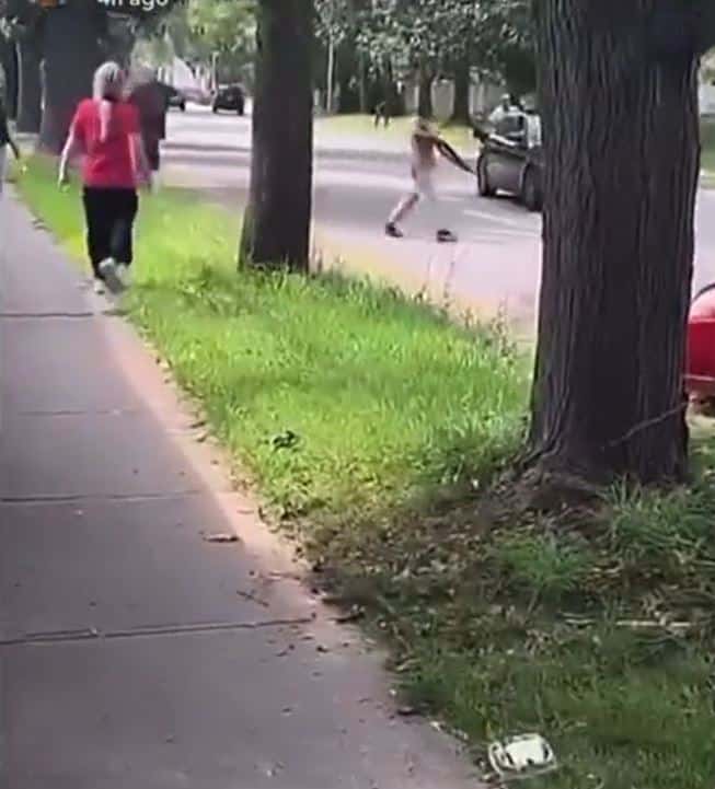 A man is visible, wandering the street with an air of menace, while pointing a shotgun almost as if he's playing the role of a lookout. (bytesintruth/X)