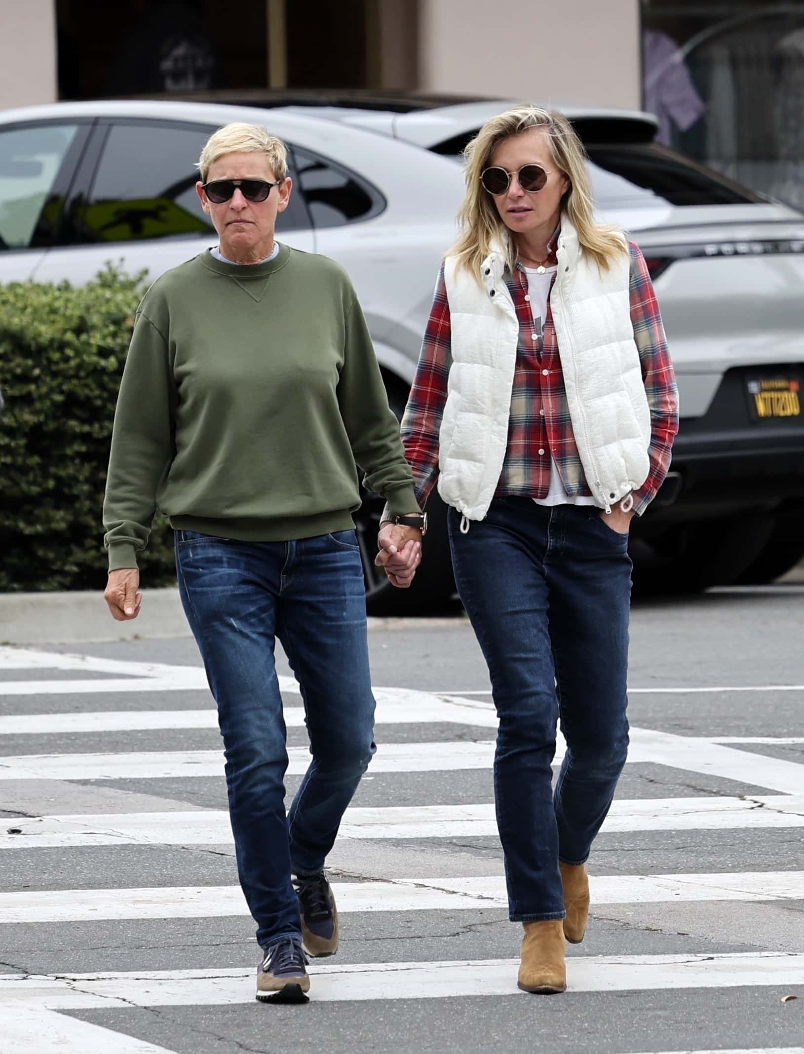 Embracing a cozy vibe, Portia, 50, rocked a puffy white vest layered gracefully over a red plaid flannel, effortlessly matched with a white top and dark denim blue jeans (Backgrid)