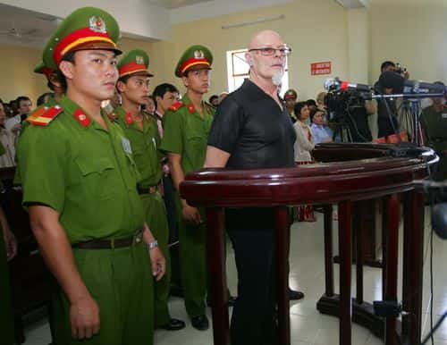 Former British glam rocker Gary Glitter listens to a guilty verdict being read out at the People's Courthouse March 3, 2006 in Ba Ria, Vietnam. Glitter, 61, received three years in prison for commiting obscene acts with two underaged girls in Vietnam.