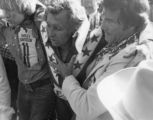 American stunt person Evel Knievel (1938 - 2007) is helped to his feet after crashing during his attempt to jump thirteen buses inside Wembley Stadium, London, 26th May 1975. (Photo by Express/Hulton Archive/Getty Images)