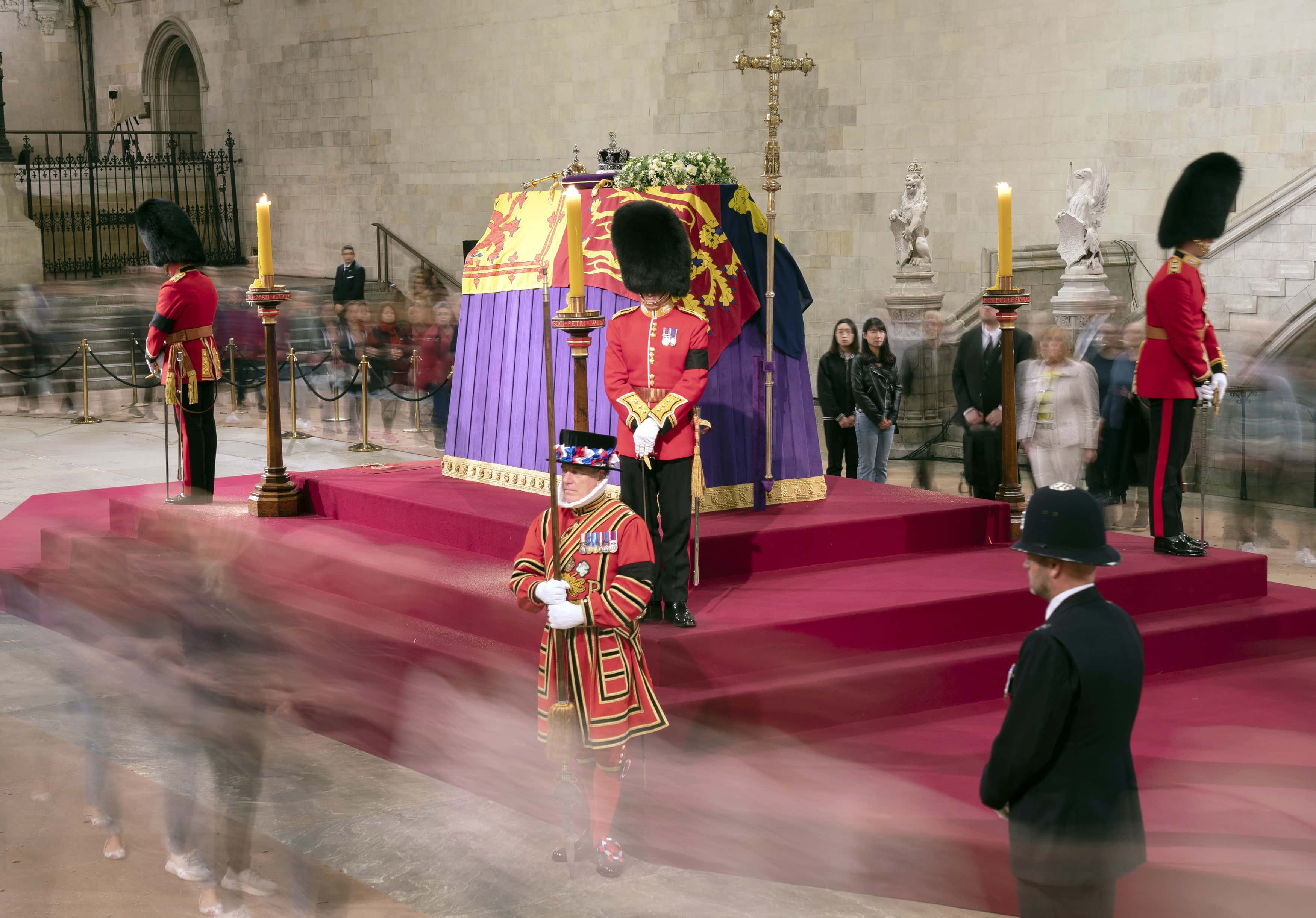 A long exposure photograph showing members of the public as they file past the coffin of Queen Elizabeth II, draped in the Royal Standard with the Imperial State Crown and the Sovereign's orb and sceptre, lying in state on the catafalque in Westminster Hall at the Palace of Westminster on September 15, 2022 in London, England. Members of the public are able to pay respects to Her Majesty Queen Elizabeth II for 23 hours a day from 17:00 on September 14, 2022 until 06:30 on September 19, 2022.  Queen Elizabeth II died at Balmoral Castle in Scotland on September 8, 2022, and is succeeded by her eldest son, King Charles III.