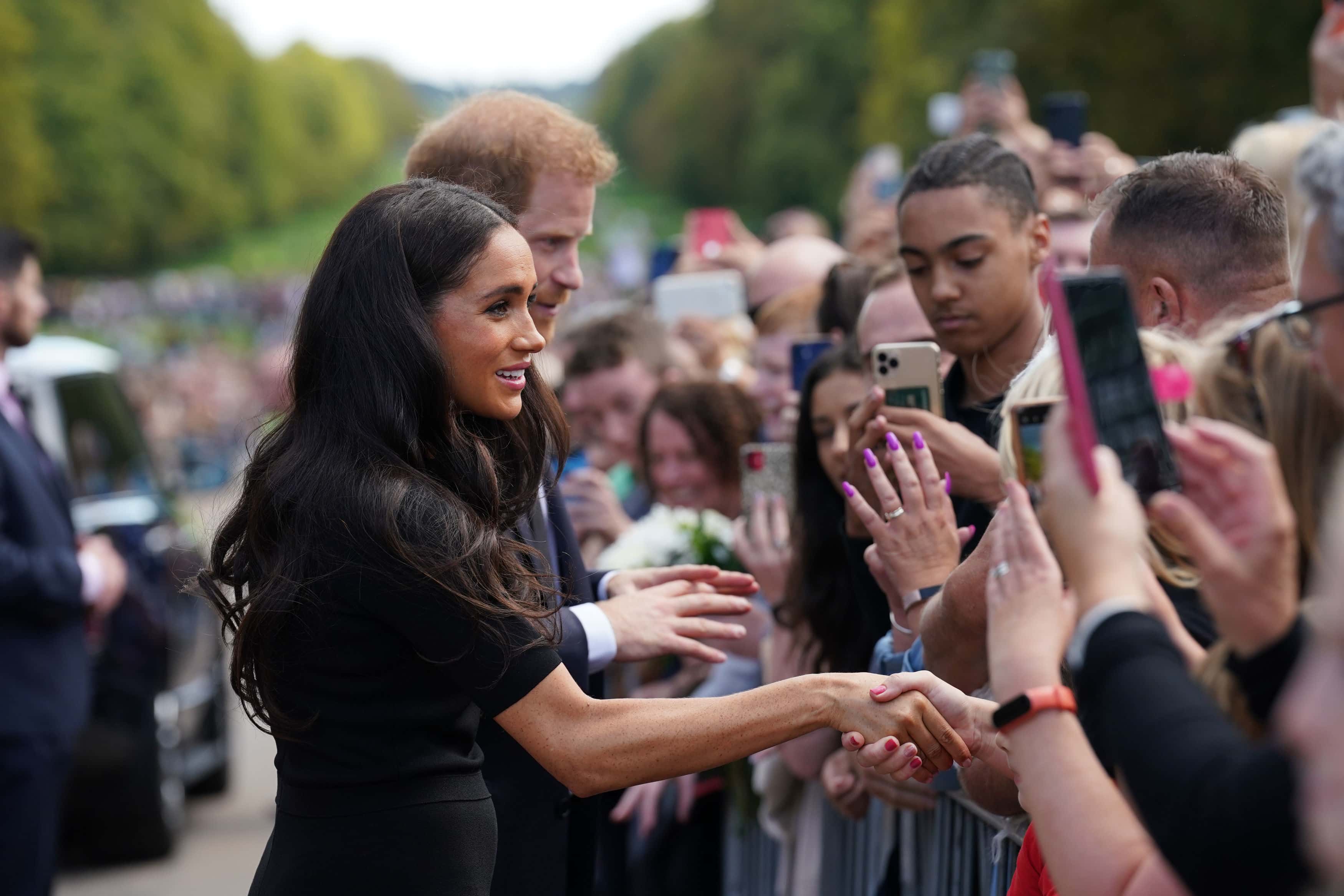 Meghan, Duchess of Sussex and Prince Harry, Duke of Sussex meet members of the public at Windsor Castle on September 10, 2022 in Windsor, England. Crowds have gathered and tributes left at the gates of Windsor Castle to Queen Elizabeth II, who died at Balmoral Castle on 8 September, 2022.