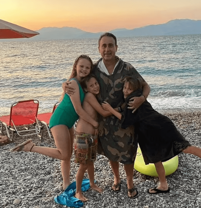 Stamatis poses with Roxy, Danny, and Teddy on the beach during their Greek holiday