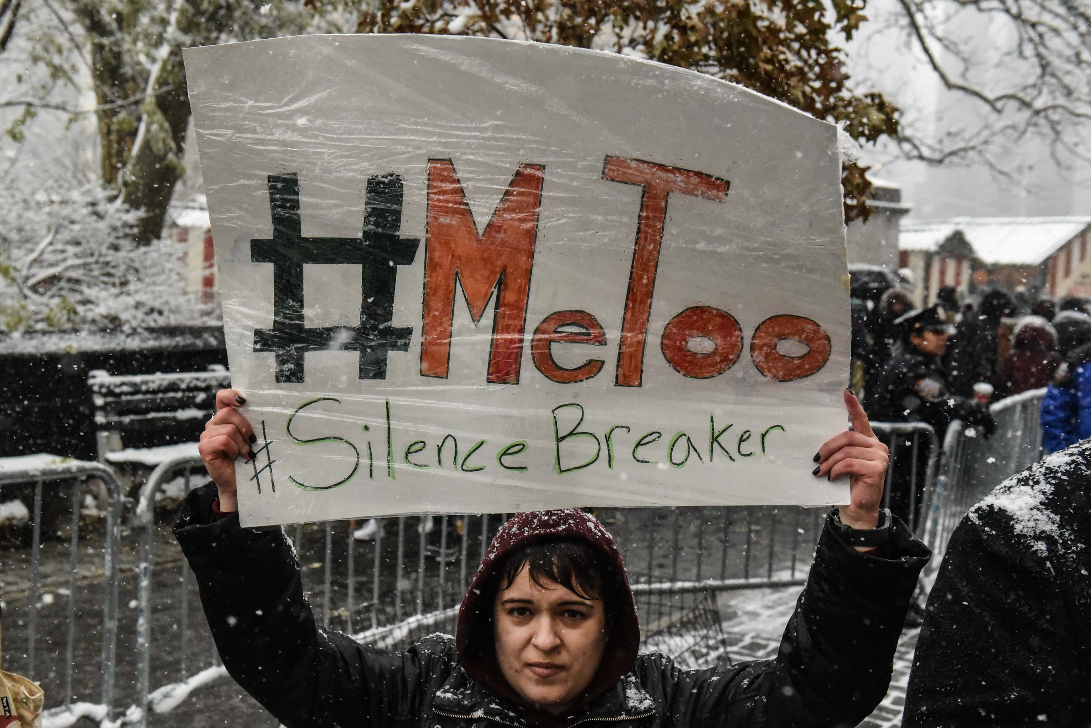 People carry signs addressing the issue of sexual harassment at a #MeToo rally outside of Trump International Hotel on December 9, 2017 in New York City.