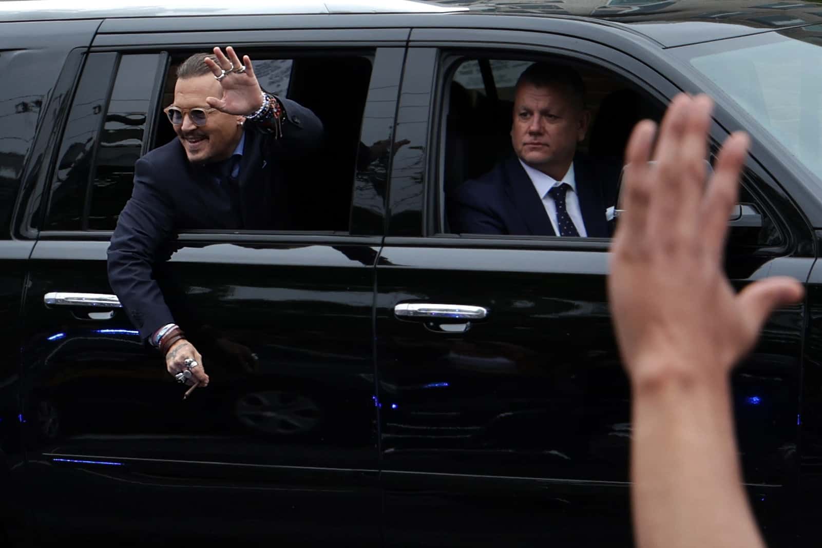 Actor Johnny Depp waves to supporters from his vehicle as he leaves a Fairfax County Courthouse May 27, 2022 in Fairfax, Virginia. Jury has started deliberation in the Depp v. Heard defamation trial, brought by Johnny Depp against his ex-wife Amber Heard. (Photo by Alex Wong/Getty Images)