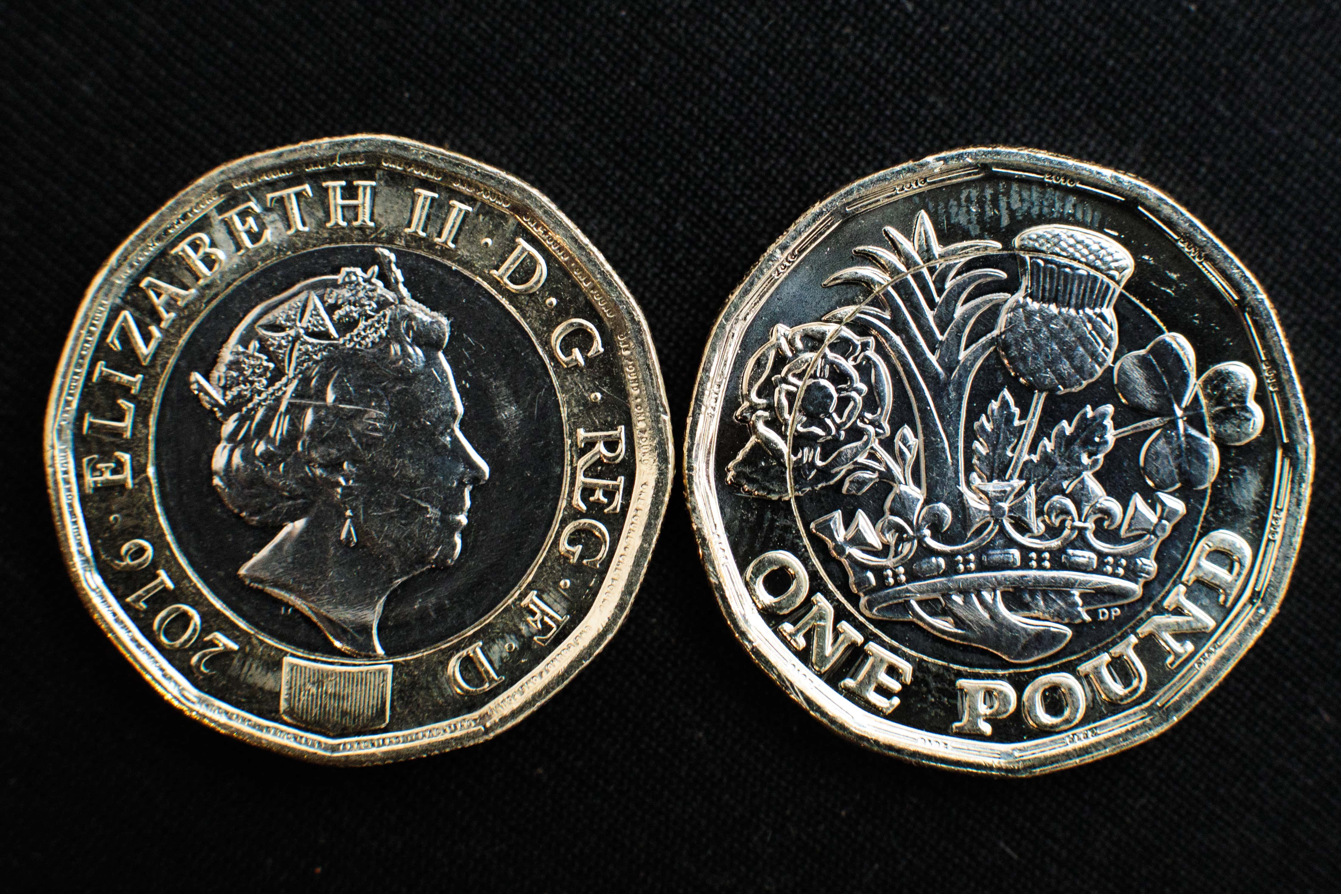 In this photo Illustration, the front and back of the newly issued £1 (GBP) (one pound) coin is arranged on display on March 28, 2017 in London, England. The new £1 coin goes into circulation today and is designed to reduce the number of counterfeits in circulation with a secure 12-sided design and bi-metallic structure.