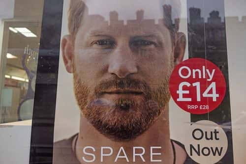 Windsor Castle's reflection is seen in the window pane as Prince Harry's book