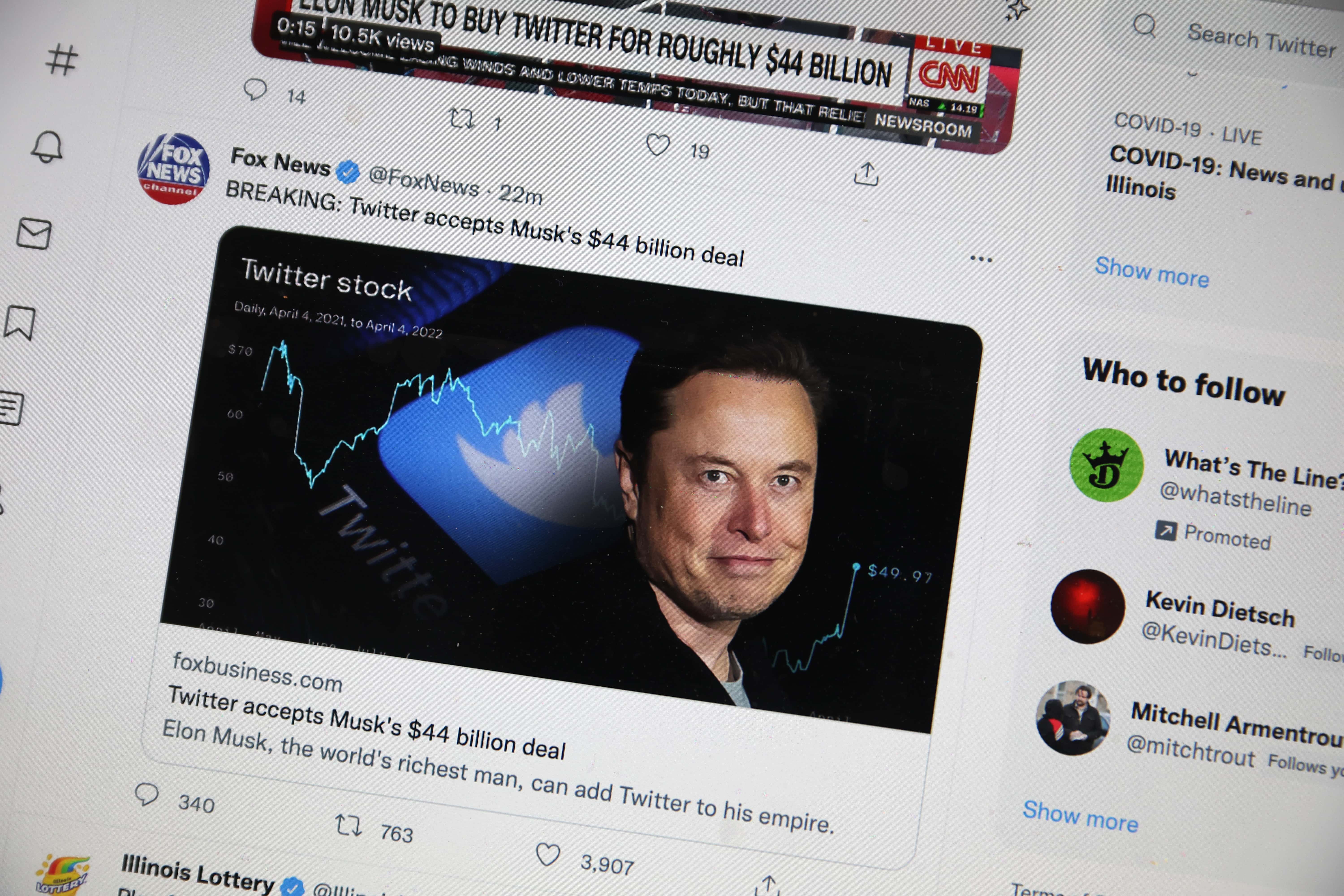 In this photo illustration, news about Elon Musk's bid to takeover Twitter is tweeted on April 25, 2022 in Chicago, Illinois. It was announced today that Twitter has accepted a $44 billion bid from Musk to acquire the company.