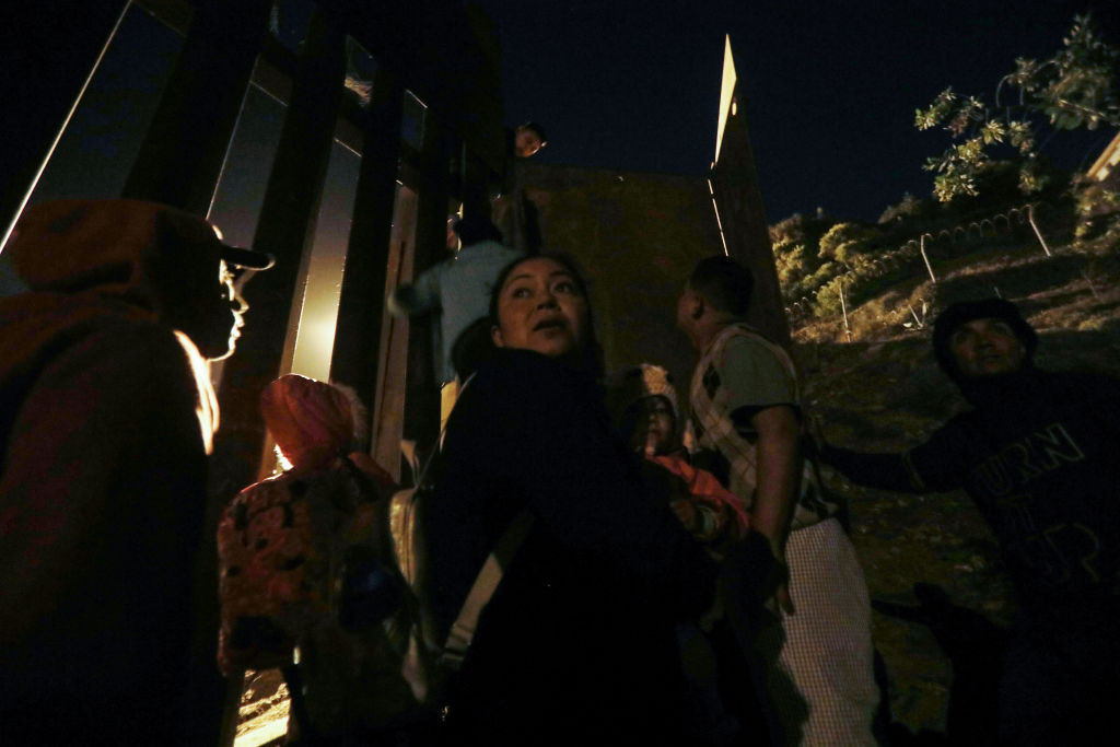 Honduran migrants prepare to climb over to the U.S. side of the U.S.-Mexico border fence on December 2, 2018, in Tijuana, Mexico. (Photo by Mario Tama/Getty Images)