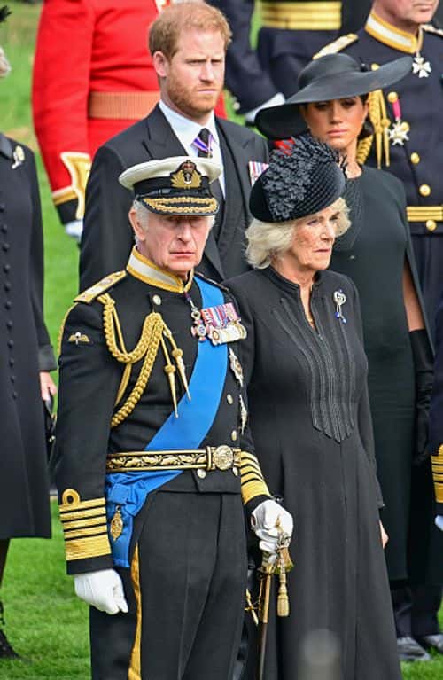 LONDON, ENGLAND - SEPTEMBER 19: Prince Harry, Duke of Sussex, Meghan, Duchess of Sussex, King Charles III and Camilla, Queen Consort observe the coffin of Queen Elizabeth II as it is transferred from the gun carriage to the hearse at Wellington Arch following the State Funeral of Queen Elizabeth II at Westminster Abbey on September 19, 2022 in London, England. Elizabeth Alexandra Mary Windsor was born in Bruton Street, Mayfair, London on 21 April 1926. She married Prince Philip in 1947 and ascended the throne of the United Kingdom and Commonwealth on 6 February 1952 after the death of her Father, King George VI. Queen Elizabeth II died at Balmoral Castle in Scotland on September 8, 2022, and is succeeded by her eldest son, King Charles III. (Photo by Andy Stenning - WPA Pool/Getty Images)