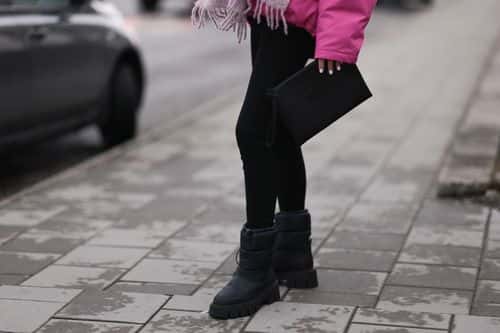 Marie Hindkaer is seen wearing pink checked Copenhagen Studios scarf, Copenhagen Studios clutch, Copenhagen Studios CPH149 recylyced nylon black boots, pink H&M studio jacket and black Toteme leggings, on November 15, 2022 in Reykjavik, Iceland.