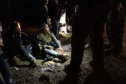 U.S. Border Patrol agents detain an immigrant from Honduras (C) near the U.S.-Mexico border on December 01, 2022 in McAllen, Texas. She was part of a group that had illegally crossed the Rio Grande from Mexico.