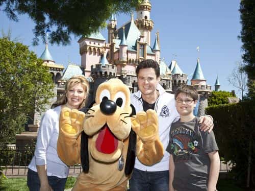 In this handout photo provided by Disney, entertainer Donny Osmond, wife Debbie and son Joshua, 12, meet Pluto at Disneyland on April 4, 2010 in Anaheim, California.