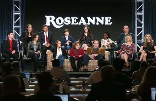 (L-R, Back Row) Executive producers Whitney Cummings and Tom Werner, actors Ames McNamera, Emma Kenney, Jayden Rey, executive producer Bruce Helford, (l-r, front row) actor Michael Fishman, executive producer/actress Sara Gilbert, actress Laurie Metcalf, executive producer/actress Roseanne Barr, actors John Goodman, Lecy Goranson and Sarah Chalke of the television show Roseanne speak onstage during the ABC Television/Disney portion of the 2018 Winter Television Critics Association Press Tour at The Langham Huntington, Pasadena on January 8, 2018 in Pasadena, California.