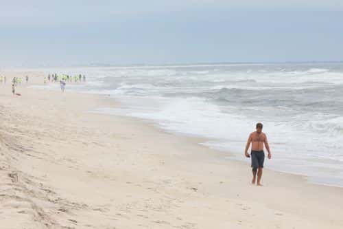 A person walks along the shore of Gilgo Beach on July 14, 2023 in Babylon, New York. A suspect in the Gilgo Beach killings was arrested in the unsolved case tied to at least 10 sets of human remains that were discovered since 2010 in suburban Long Island.  The suspect Rex Heuermann is expected to be arraigned after his arrest Thursday night.