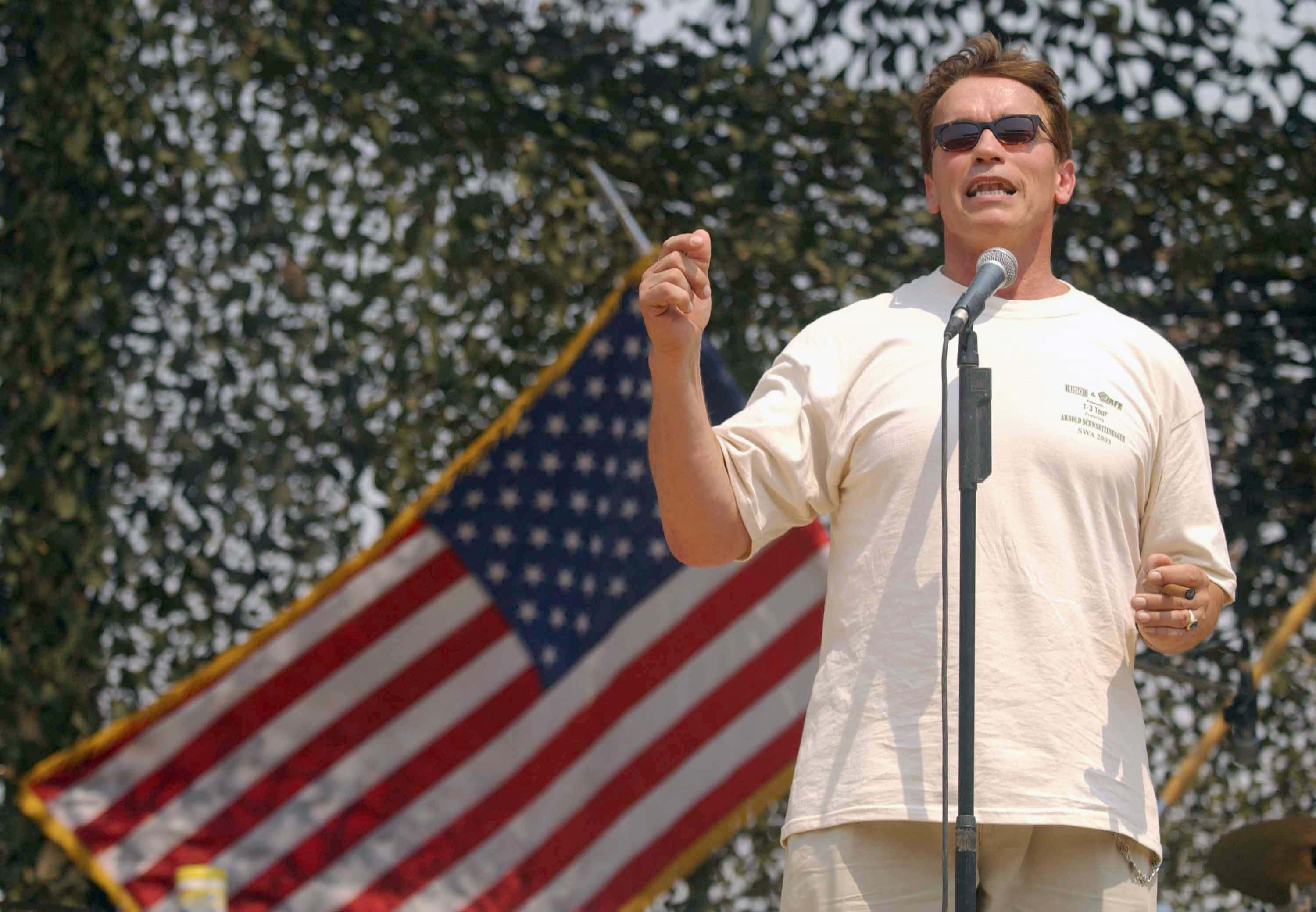 Actor Arnold Schwarzenegger speaks in front of hundreds of U.S soldiers at the U.S. LSA (Logistic Support Area) Anaconda Balad airfield July 4, 2003, about 76 km north of Baghdad, Iraq. Schwarzenegger announced on August 6, 2003, that he will run for California governor. (Photo by Getty Images)