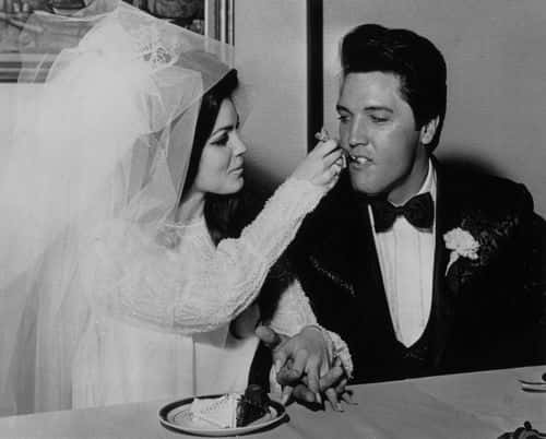 Elvis Presley (1935 - 1977) being fed a mouthful of wedding cake by his bride Priscilla Beaulieu at the Aladdin Hotel, Las Vegas.   (Photo by Keystone/Getty Images)